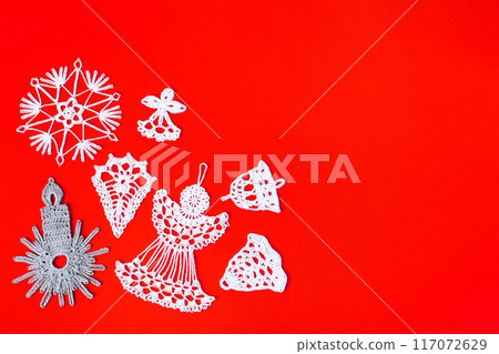 Knitted white and gray Christmas decorations in form of snowflakes, bells, candles on red background with place for text. Winter knitting creativity. Holiday concept, gifts, greeting card Knitted white and gray Christmas decorations in form of snowflakes, bells, candles on red background with place for text. Winter knitting creativity. Holiday concept, gifts, greeting card 117072629