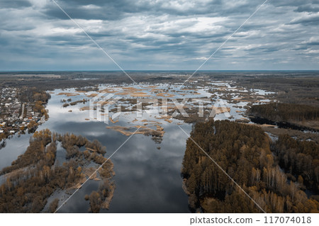 A stunning aerial view of the serene marshlands winding waterways lies under a dramatic, cloudy sky A stunning aerial view of the serene marshlands winding waterways lies under a dramatic, cloudy sky 117074018