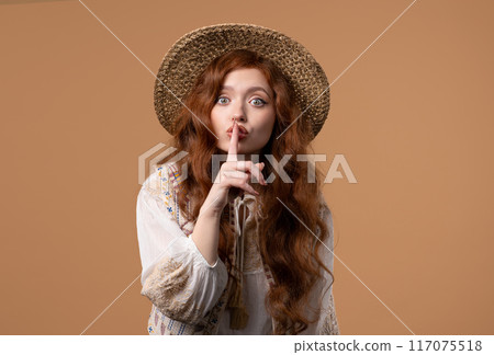 Gossiper pretty woman with finger on lips - shh, secret, silence, hush on beige 117075518