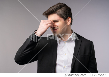Businessman having headache,studio portrait.Migraine,hypertension,magnetic storm 117075546