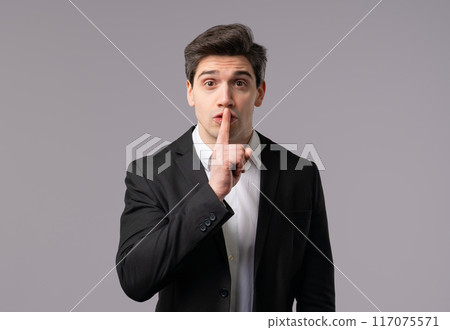 Gossiper businessman, Gesture Of Shh, Secret, Silence, Conspiracy, Gossip, Rumors, Hush on grey studio background Gossiper businessman, Gesture Of Shh, Secret, Silence, Conspiracy, Gossip, Rumors, Hush on grey studio background 117075571
