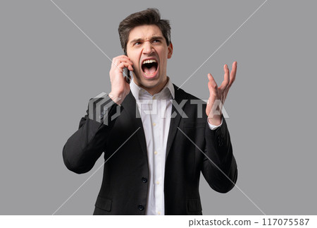 Angry mature businessman quarreling, screaming talking on mobile phone. Mischief boss manager man in stress, conflict Angry mature businessman quarreling, screaming talking on mobile phone. Mischief boss manager man in stress, conflict 117075587