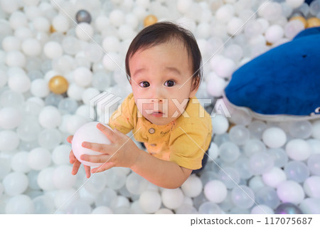 Happy baby kid playing with balls in ball pool 117075687