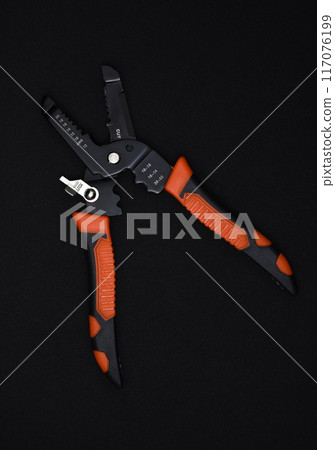 Insulation puller or stripper is an electrical installation tool on a black background. 117076199