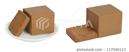 Brown cheese. Norwegian brunost in a ceramic bowl isolated on white background with full depth of field 117080123