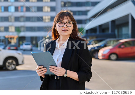 Mature woman manager agent using digital tablet for work, city background Mature woman manager agent using digital tablet for work, city background 117080639