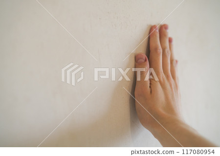 closeup young man hand touching plastered wall closeup young man hand touching plastered wall 117080954