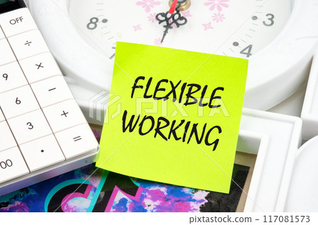 Day working week concept. FLEXIBLE WORKING words on a light green sticker on the background of a clock near the calculator Day working week concept. FLEXIBLE WORKING words on a light green sticker on the background of a clock near the calculator 117081573