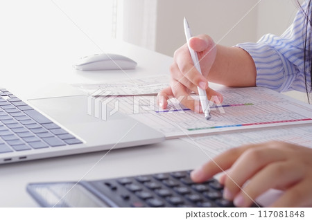 A woman filling out tax return documents 117081848
