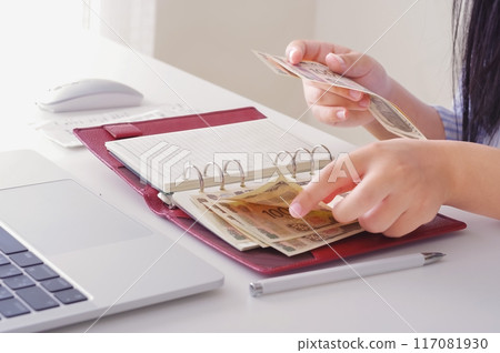 Woman's hands counting money 117081930