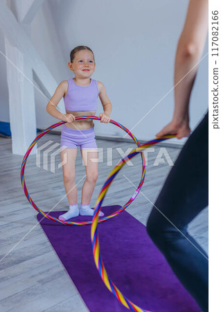 Gymnast child performs an exercise with hoop.Children's professional sports. Gymnast child performs an exercise with hoop.Children's professional sports. 117082166
