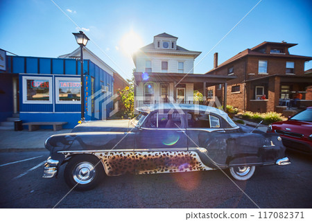 Vintage Car with Leopard Accents on Small Town Street, Lens Flare Effect Vintage Car with Leopard Accents on Small Town Street, Lens Flare Effect 117082371