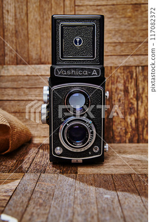 Vintage Yashica-A Twin-Lens Reflex Camera on Wooden Surface in Studio Vintage Yashica-A Twin-Lens Reflex Camera on Wooden Surface in Studio 117082372
