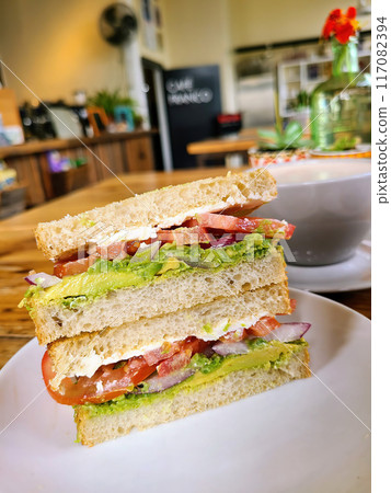 Fresh BLT Sandwich on White Plate in Cozy cafe, Eye-Level View 117082394