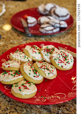 Festive Christmas Cookies on Red Plate with Holiday Decor Background 117082436