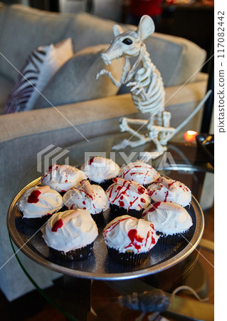 Spooky Bloody Finger Halloween Cupcakes with Rodent Skeleton in Party Setting 117082442