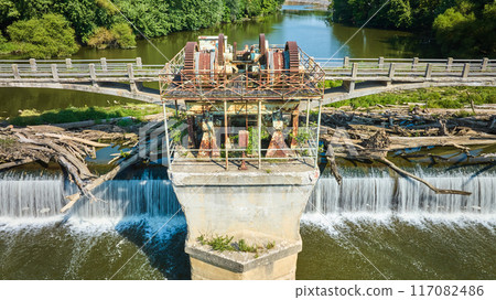 Straight on Maumee River Dam rusty gears and equipment between bridges with logs over waterfalls aerial Fort Wayne, IN Straight on Maumee River Dam rusty gears and equipment between bridges with logs over waterfalls aerial Fort Wayne, IN 117082486