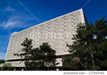 Modern Angular Building with Textured Facade Framed by Green Trees in Indiana 117082492