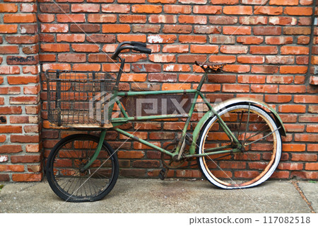 Vintage Green Bicycle Against Rustic Brick Wall in Urban Setting Vintage Green Bicycle Against Rustic Brick Wall in Urban Setting 117082518