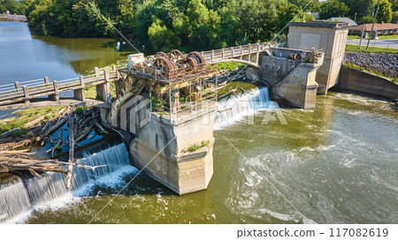 Maumee River Dam aerial rusty gears and floating logs chocking water surface over waterfalls Fort Wayne, IN Maumee River Dam aerial rusty gears and floating logs chocking water surface over waterfalls Fort Wayne, IN 117082619