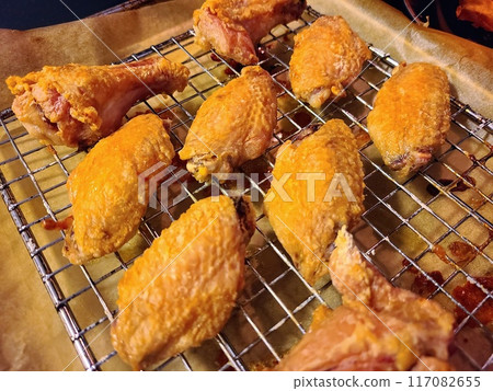 Crispy Fried Chicken Wings and Drumsticks on Cooling Rack 117082655