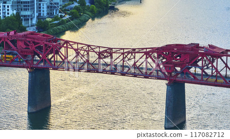 Aerial View of Red Truss Bridge with Yellow Tram at Golden Hour Aerial View of Red Truss Bridge with Yellow Tram at Golden Hour 117082712