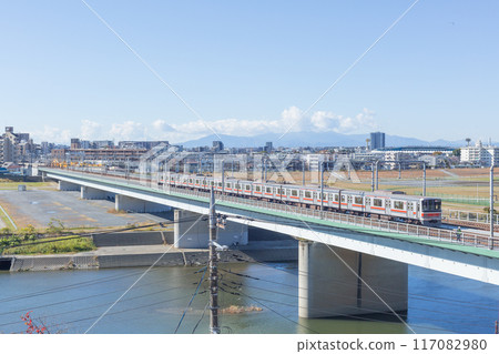 [Japan] Autumn sky and train passing over the tracks over the Tama River as seen from Sengen Shrine in Ota Ward, Tokyo 117082980