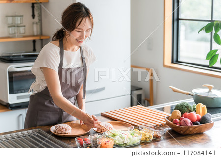 一位家庭主婦在廚房準備一盤午餐 117084141