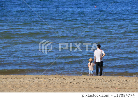 Parents and children playing on the beach Parents and children looking at the sea from the beach Summer vacation morning beach 117084774