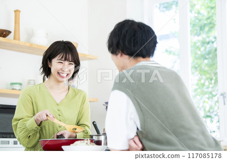 Smiling young woman cooking 117085178