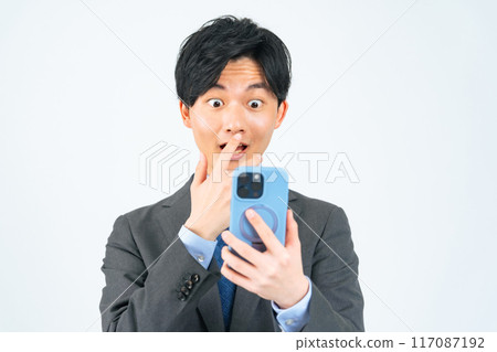 A male business person is surprised at his smartphone 117087192