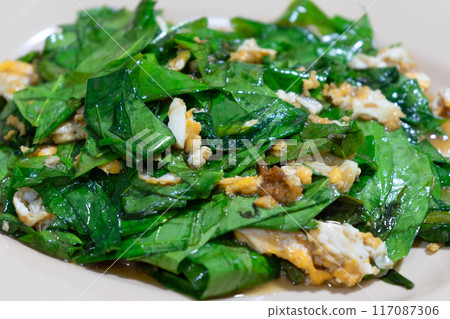 Closeup stir fired of vegetable with the egg. Delicious Thai food.Stir-fried Malindjo Leaves with Egg Closeup stir fired of vegetable with the egg. Delicious Thai food.Stir-fried Malindjo Leaves with Egg 117087306