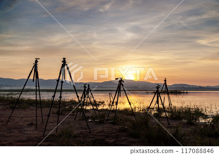 View of group of tripod and the lake background at sunrise sky. Landscape photography. View of group of tripod and the lake background at sunrise sky. Landscape photography. 117088846