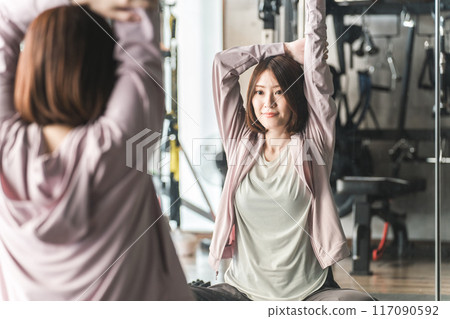 年輕的亞洲女性在健身房做伸展和彈性練習 117090592