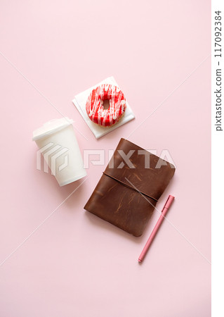 Disposable coffee cup, donut and brown notebook. Time break and productivity concept. Disposable coffee cup, donut and brown notebook. Time break and productivity concept. 117092384