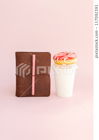 Brown leather journal and paper coffee cup with donut. Creativity or coffee break concept. 117092391