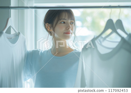 Image of a laundry room: young woman Image of a laundry room: young woman 117092453