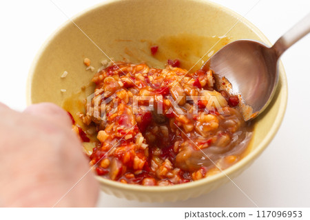 Hands preparing spicy sauce for Thai dish Khao Man Gai 117096953