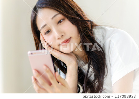 一位女士板著臉看著她的智慧型手機 117098958
