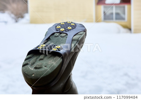 Studded overlay on sole of footwear will help prevent slipping on black ice and prevent injury. 117099484