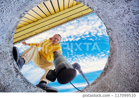 Homeowner submerging submersible sewage pump in wastewater of septic tank. 117099510