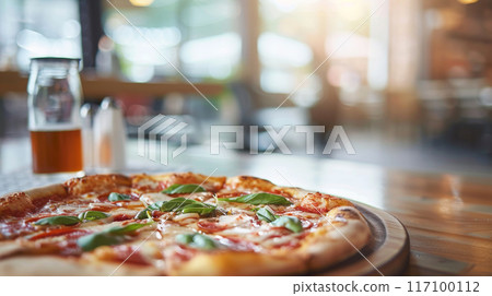 Close-up of fresh baked Italian pizza on old rustic wooden table in restaurant background 117100112