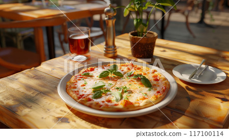 Close-up of fresh baked Italian pizza on old rustic wooden table in restaurant background 117100114