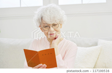 Senior female looking at pension book Senior female looking at pension book 117100516