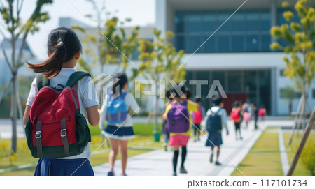 back view of schoolgirl with backpack running to school. 117101734