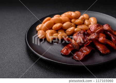 Fried sausages sliced with salt and spices as an ingredient for an English breakfast 117103060