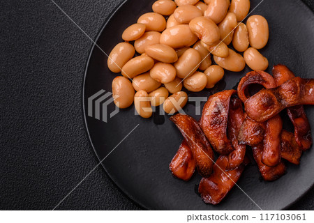 Fried sausages sliced with salt and spices as an ingredient for an English breakfast 117103061