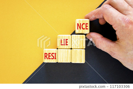 Resilience symbol. Concept word Resilience on beautiful wooden blocks. Businessman hand. Beautiful yellow and black background. Business resilience concept. Copy space. Resilience symbol. Concept word Resilience on beautiful wooden blocks. Businessman hand. Beautiful yellow and black background. Business resilience concept. Copy space. 117103306
