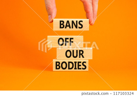Bans off our bodies symbol. Concept words Bans off our bodies on wooden blocks on beautiful orange table orange background. Women rights concept. Business social issues bans off our bodies concept. 117103324