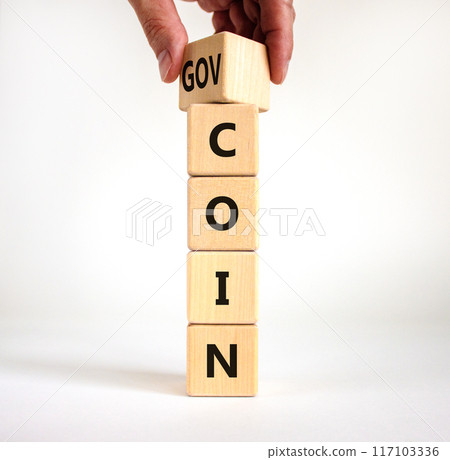 Govcoin symbol. Businessman turns wooden cubes and changes the word 'coin' to 'govcoin'. Beautiful white table, white background, copy space. Business, govcoin concept. Govcoin symbol. Businessman turns wooden cubes and changes the word 'coin' to 'govcoin'. Beautiful white table, white background, copy space. Business, govcoin concept. 117103336